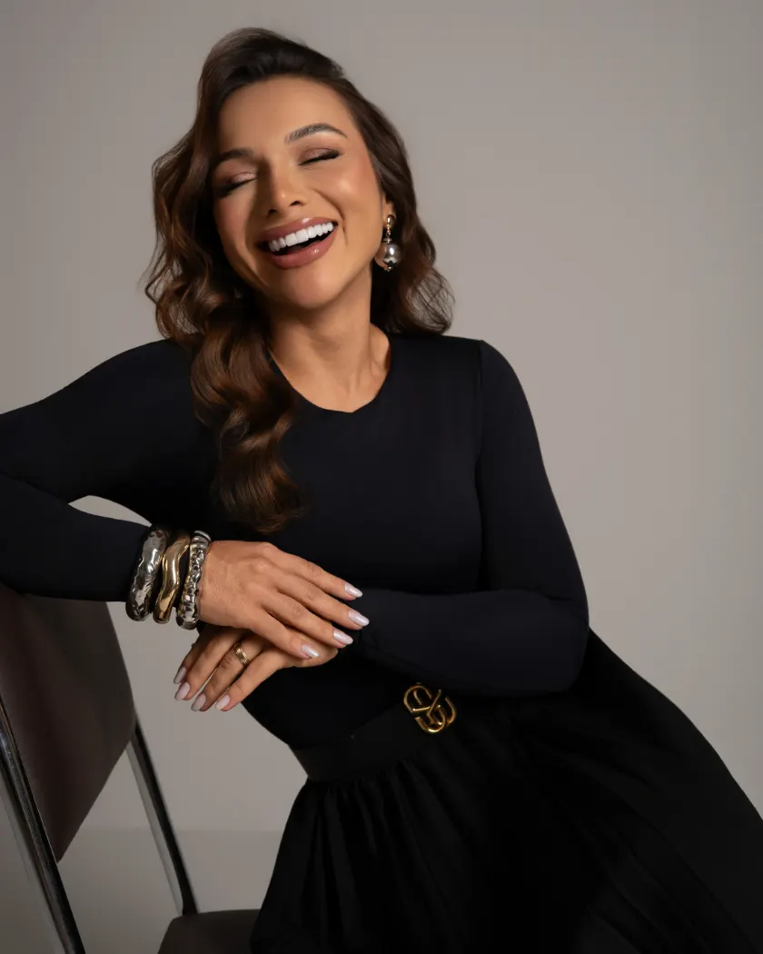 Paciente sorrindo em retrato editorial com vestido escuro